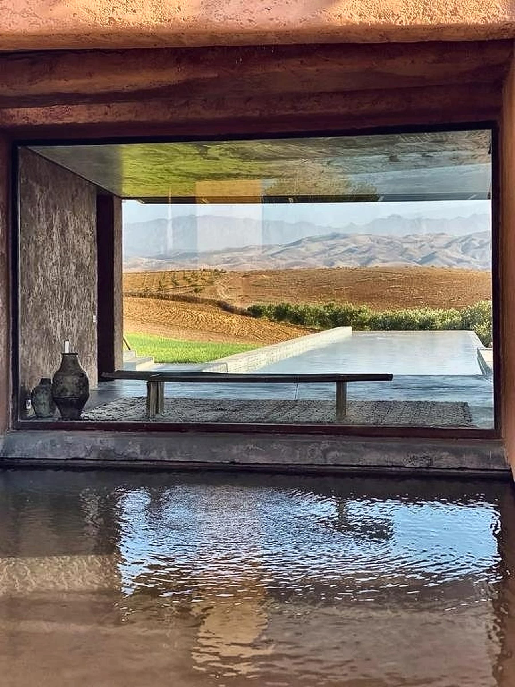 Intérieur de Villa K, cadrage de cèdre ouvert sur la piscine noire et l'Atlas — Studio KO, Marrakech